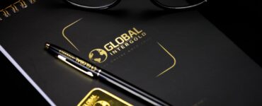 An elegant setup with a notebook, pen, and gold bar, embodying luxury and style.