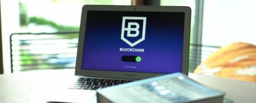Laptop displaying blockchain connecting screen in modern setting.