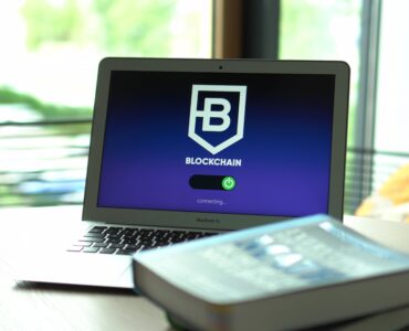 Laptop displaying blockchain connecting screen in modern setting.